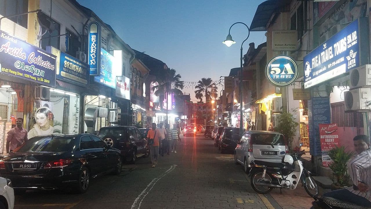 Little India in George Town at dusk, shop signs lit along the street