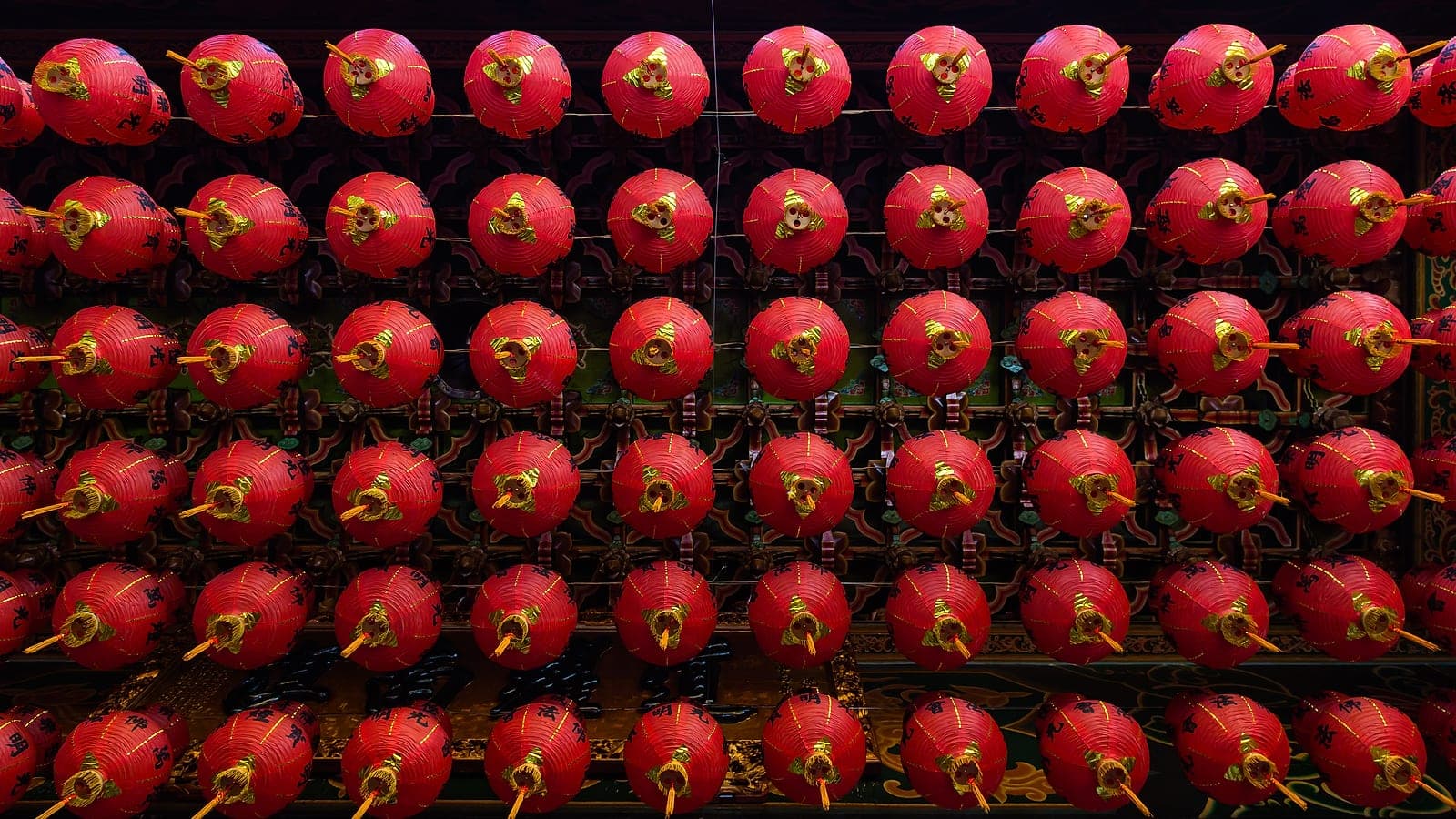 Rows of red lanterns hung from the temple ceiling — festival-season interior halls