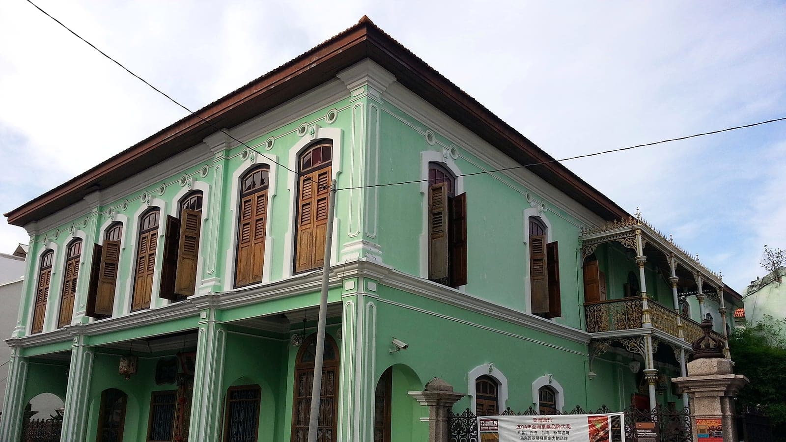 The mansion's ornate green façade